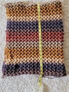 a crocheted blanket with a measuring tape on it