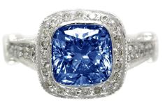 a blue and white diamond ring with diamonds around it