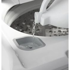 a close up of a washing machine with water pouring from the top into the washer