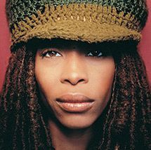 a black and white photo of a woman with dreadlocks wearing a knitted hat