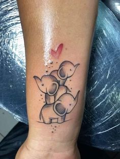 a couple of elephants on the ankle with a red heart in the middle of it