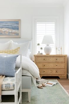 a bedroom with white bedding and blue pillows