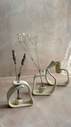 three ceramic vases with flowers in them