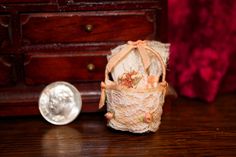 a small doll is sitting on the floor next to a purse and a dime coin