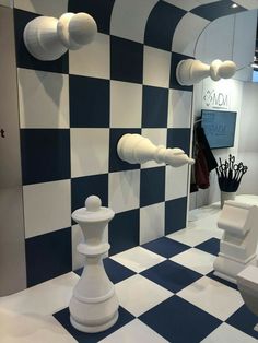 a room with checkered walls and white furniture on the floor in front of it