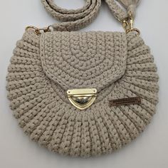 a crocheted purse with a gold clasp on the front and strap around it