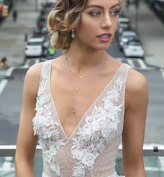 a woman in a wedding dress standing on the street