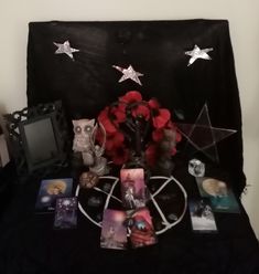 a table topped with pictures and candles on top of a black cloth covered bed cover