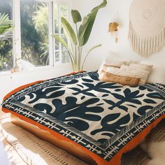 a bed with an orange and black comforter on it