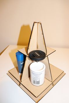 an open cardboard box with a container and some other items in it sitting on a table