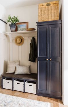 an entryway with a coat rack, bench and storage bins