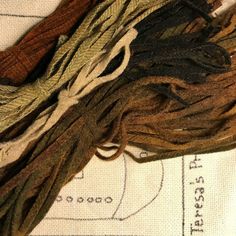 several different colored yarns laid out on top of each other, including brown and green