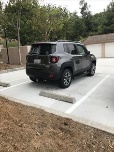 a jeep parked in a parking lot with trees and bushes around the space area behind it