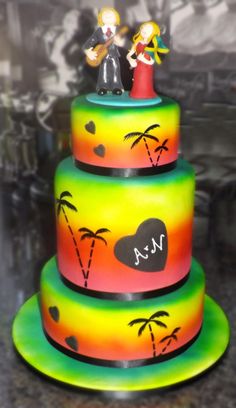 a multi layer cake decorated with palm trees and hearts