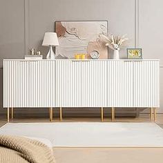 a living room with a white rug on the floor and a sideboard in front of it