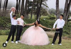 three people in formal wear are holding hands and posing for the camera with their arms outstretched