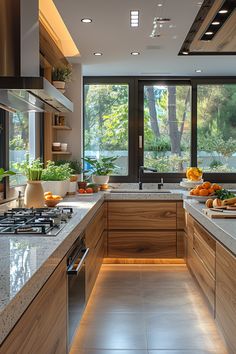 Light-filled Elegance: This modern kitchen blends sleek wood cabinetry with airy, light-colored countertops. Potted plants and fresh produce introduce a vibrant, natural feel, complemented by large windows that frame a view of surrounding greenery. Experience the inviting warmth and natural harmony that define NOVASPACE PROMOciones' passive house approach. Embrace sustainable living today! Colored Countertops, Passive House Design, Passive House, Chic Kitchen, Eco Chic, Sustainable Architecture, Fresh Produce, Large Windows, Sustainable Living