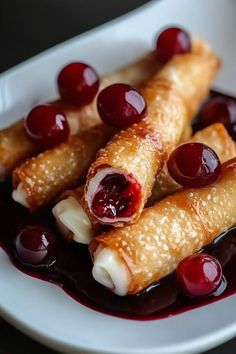 crepes with cherries are on a white plate and garnished with sauce