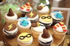 cupcakes decorated with harry potter symbols are on a cake platter at a birthday party