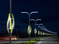 an image of street lights at night with cars passing by on the road and in the background