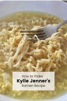 a white bowl filled with rice and noodles next to a fork on top of it