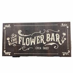 a wooden sign that says the flower bar open daily