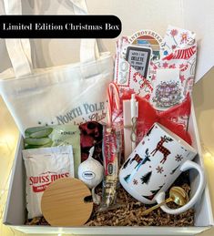 a white box filled with lots of christmas items next to a cup and saucer