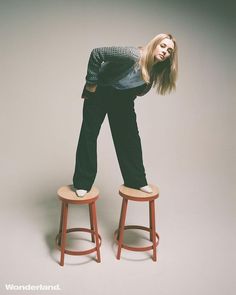 a woman standing on top of two stools