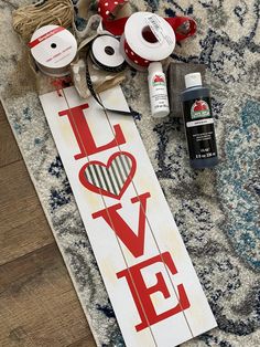 a sign that says love on it next to some spools of thread