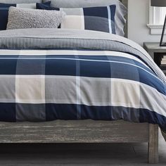 a bed with blue and white checkered comforter set on it's side