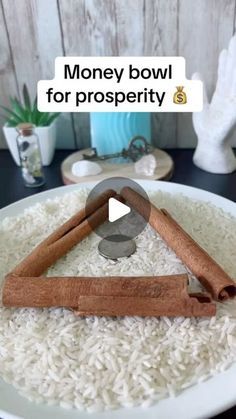 a bowl filled with rice and cinnamons on top of a table next to a vase