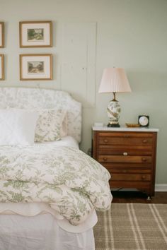 a white bed sitting in a bedroom next to two framed pictures