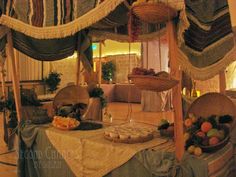 a table topped with lots of food under a canopy