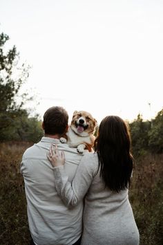 a man and woman holding a dog in their arms