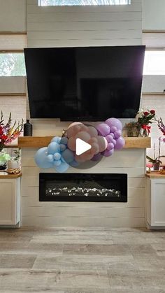 a living room filled with furniture and a flat screen tv mounted on a wall above a fire place