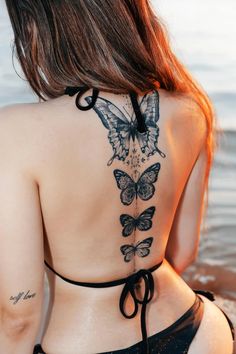 the back of a woman's body with butterfly tattoos on her upper and lower back