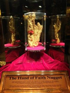 the hand of faith nugget is on display in glass cases with red cloth