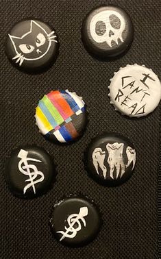 six buttons with different designs on them sitting next to each other in a black case