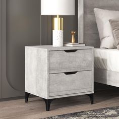 a nightstand with two drawers and a lamp on it in front of a white bed