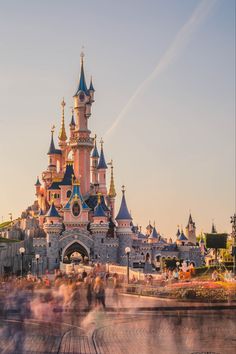 people are walking around in front of a castle