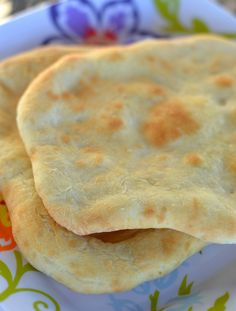 two pita breads sitting on top of a colorful plate