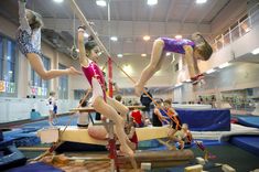 some girls are doing acrobatic tricks in an indoor gym