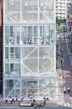 an aerial view of a building with people walking on the sidewalk and cars driving down the street