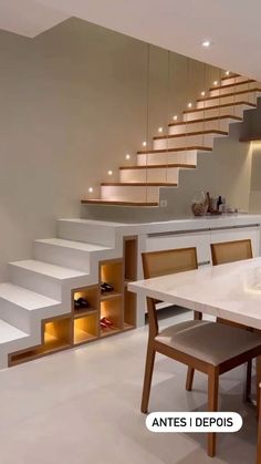 a dining room table and some chairs in front of a stair case with lights on it