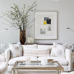 a living room filled with furniture and a painting on the wall above it's coffee table