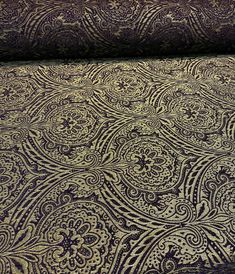 the fabric is purple and gold with paisley designs on it, as well as an intricate pattern