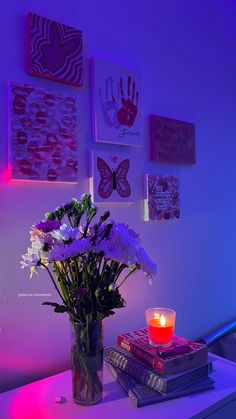 a vase filled with flowers sitting on top of a table next to a lit candle