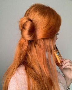 a woman with long red hair is brushing her teeth