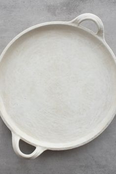 an empty white dish on a gray surface