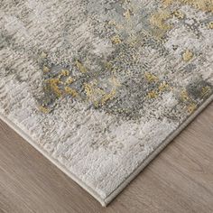 a gray and yellow rug on top of a wooden floor